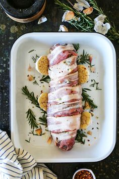 a white plate topped with meat covered in sauces and garnished with herbs