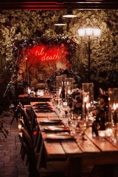 a long table is set up with candles and place settings for an outdoor dinner party