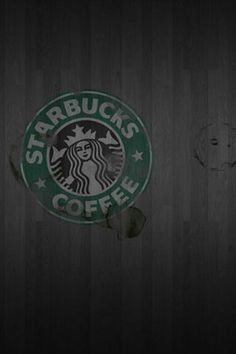 the starbucks logo is shown on a dark wood wall with peeling paint and chipping