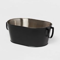 a large black metal pot with handles on the top and bottom, sitting in front of a white background