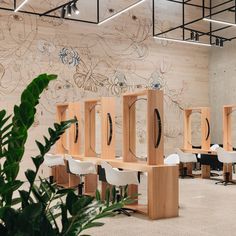 an empty room with chairs and wooden partitions in front of a wall painted with flowers