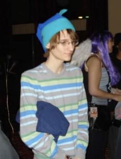 a young man wearing a blue hat and striped shirt