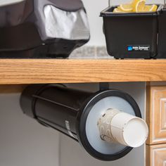 a close up of a coffee cup on a shelf near a toaster and juicer