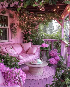 the porch is covered in pink flowers and wicker furniture, with string lights strung from the ceiling