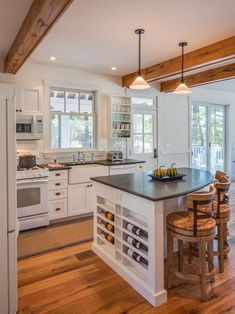 a kitchen with white cabinets and wooden floors