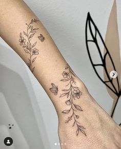 a woman's arm with flowers and butterflies on the left side of her arm