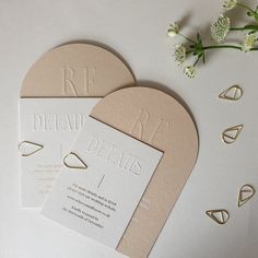 the wedding stationery is laid out on top of each other, with flowers in the background