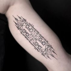 a black and white photo of a tattoo on the left arm with an intricate design