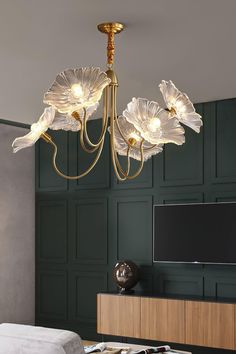 a chandelier hanging from the ceiling in a room with green walls and furniture