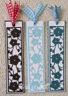 three bookmarks with flowers and gingham ribbons hanging from each one's sides