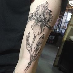 a black and white flower tattoo on the arm