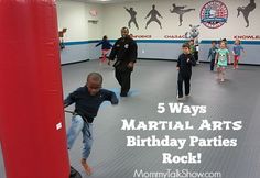 kids are practicing martial moves in a gym with red punching bags and an adult standing behind them