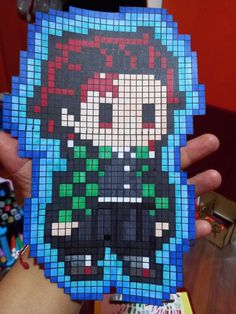 a person holding up a piece of art made out of legos