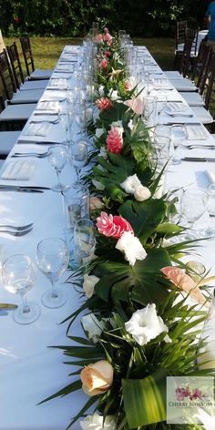 a long table with flowers and wine glasses on it