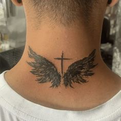 the back of a man's neck with an angel wing and cross tattoo on it