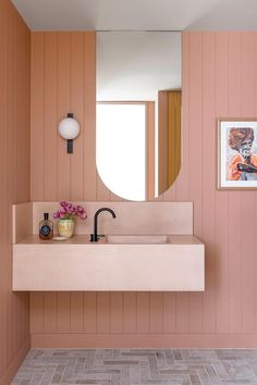 a bathroom with pink walls and wood paneling on the walls is shown in this image