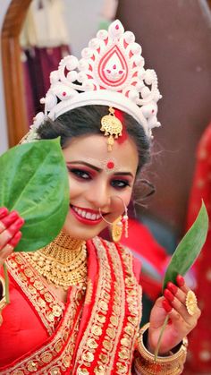 a woman wearing a tiara and holding a leaf