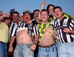 a group of men standing next to each other in front of a crowd wearing striped shirts