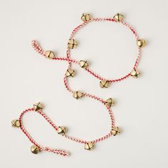 two red and gold bracelets with bells on white background, one is for sale