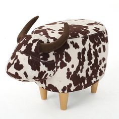 a cow shaped stool with brown and white spots on it's face, sitting in front of a white background