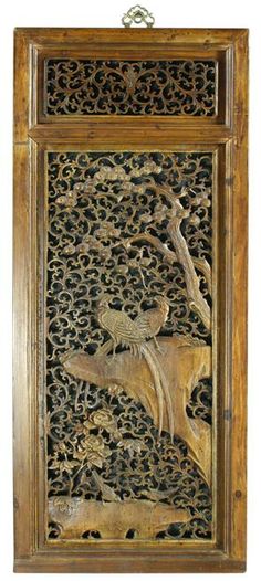 an intricate carved wood panel with birds and flowers