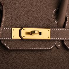 This exquisite Birkin bag, crafted in Etoupe Togo leather, features elegant gold hardware and contrasting stitching. The design includes a front flap with two straps secured by a center toggle closure, a clochette with a lock and two keys, and double rolled handles. The interior, lined with etoupe chevre leather, boasts a zip pocket with an Hermès engraved zipper pull and an open pocket on the opposite side, offering both style and functionality. Leather: Togo Hardware: Gold Style: Birkin Condit Elegant Gold Satchel With Turn-lock Closure, Gold Top Handle Satchel With Hasp Closure, Classic Gold Satchel With Brass Hardware, Gold Satchel With Hasp Closure For Formal Occasions, Formal Gold Satchel With Hasp Closure, Gold Satchel With Gold-tone Hardware, Classic Gold Satchel With Turn-lock Closure, Luxury Togo Leather Office Bag, Luxury Brown Satchel With Hasp Closure