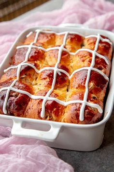 a casserole dish with hotdogs and cheese in it on a pink blanket