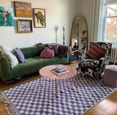 a living room with couches, chairs and rugs in front of a window