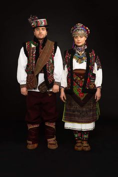 two people dressed in traditional clothing standing next to each other on a black background photo