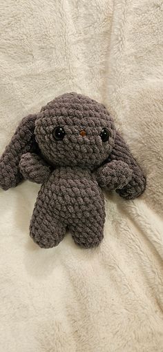 a crocheted stuffed animal laying on top of a white blanket