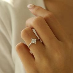 a woman's hand with a diamond ring on it