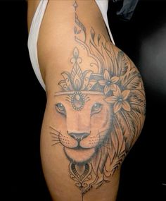 a woman's thigh with a lion tattoo on the side and flowers in her hair