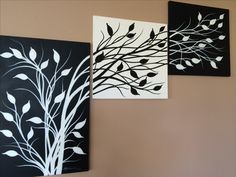 three black and white paintings hanging on the wall next to each other with leaves painted on them