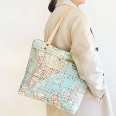 World Map canvas tote purse for travel and for everyday use. With strong leather handles, this shoulder bag has a few pockets, waterproof lining and zipper top closure. Personalize your World Map Bag with embossed initials or a name on the zipper pull, or customize it adding a crossbody strap and choosing leather colour.  --- Materials:  - Exterior made with cotton blend upholstery fabric with world map print.  - Vegetable tanned leather handles with polished edges. - Lined with waterproof cordu Coated Canvas Tote Shoulder Bag For Weekend Trips, Weekend Tote Shoulder Bag In Coated Canvas, Coated Canvas Bags With Leather Handles For Trips, Coated Canvas Bag With Leather Handles For Trips, Travel Canvas Tote Bag With Zipper Closure, Travel Shoulder Bag With Canvas Lining, Travel Canvas Satchel With Zipper Closure, Canvas Shoulder Bag With Removable Pouch For Weekend Trips, Travel Canvas Satchel With Removable Pouch