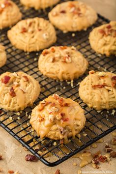 several cookies cooling on a wire rack with nuts scattered around them and topped with icing