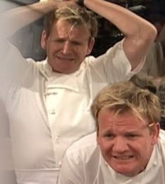 two men in white shirts and one is holding his head with both hands while the other man holds his hair