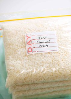 three bags of rice sitting on top of a blue tablecloth with a price tag