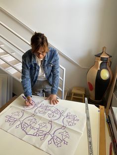 a woman is drawing on a piece of paper