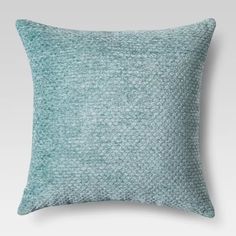 a blue pillow on a white surface with a green pattern in the middle and bottom