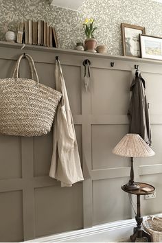 a coat rack with two coats hanging from it's hooks and a lamp on the floor