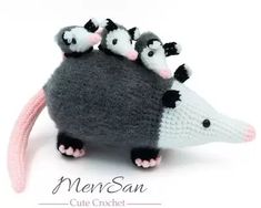 a knitted toy with three small black and white possles on it's back