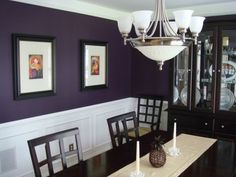 a dining room with purple walls and white trim