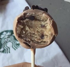 a close up of a person holding a chocolate chip ice cream lollipop