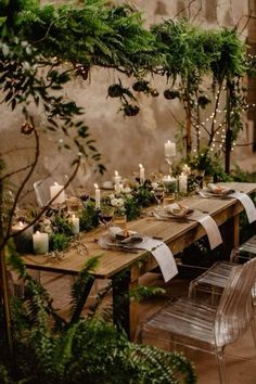 a long table with candles and greenery on it