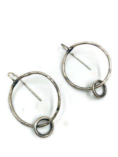 "These \"go to \" every day earrings are simple and beautiful . A circle that connects to a smaller ring that has a nice kinetic quality to them. They are organic in shape, slightly irregular ; crafted from textured sterling silver . Oxidised and brushed to a darker & satin finish. They measure 1 3/4\" long X 1 1/4\" wide." Modern Twist Round Earrings For Everyday, Nickel-free Round Earrings With A Modern Twist, Contemporary Round Earrings, Contemporary Round Earrings For Everyday, Contemporary Everyday Round Earrings, Minimalist Hand Forged Circle Hoop Earrings, Modern Hand Forged Circle Hoop Earrings, Modern Hammered Open Circle Earrings, Metal Open Circle Earrings