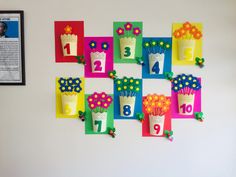 the wall is decorated with colorful paper flowers and numbers for each child's birthday