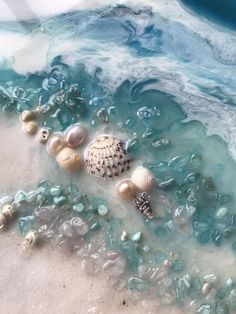 seashells and pearls are on the sand at the beach