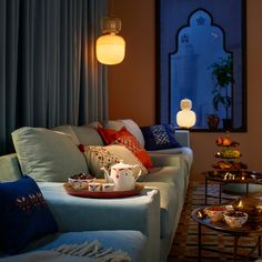 a living room filled with lots of furniture next to a window covered in blue curtains