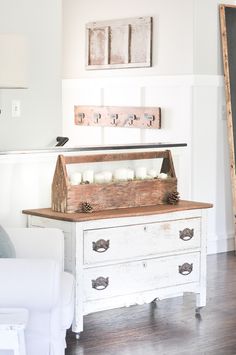 an old chest with candles on top in a living room area next to a white couch