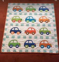 a quilted wall hanging with cars on it